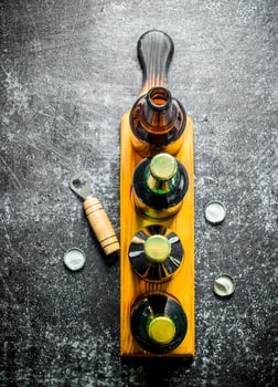 Beer bottles on a stand and opener. photo