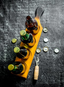 Beer bottles on a stand and opener. photo