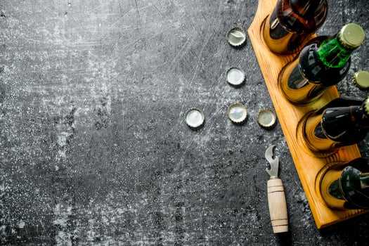 Beer bottles on a stand and opener. photo