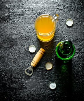 Beer in a glass and an open glass bottle with opener. photo