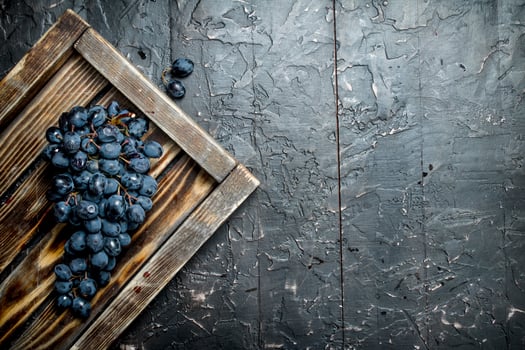 Black grapes on a wooden tray. photo