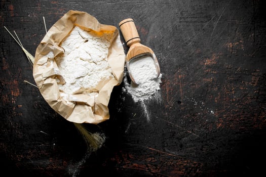 Flour in paper with a scoop and spikelets. photo
