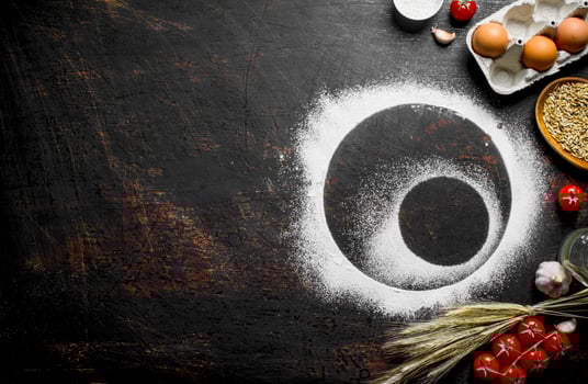Round frame made of flour with spikelets, grain and eggs. photo