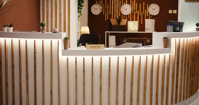 Rack focus shot of stylish travel vacation accommodation lounge interior with posh green furniture ready to welcome guests. Empty luxury hotel foyer with check in reception front desk photo
