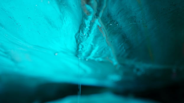 Vatnajokull blue ice rock inside glacier crevasse in icelandic scenery, arctic landscape with icy cracked rocks. Transparent structure in ice cave, frosty polar destination. Handheld shot. photo