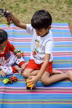 Two happy boys in society park, happy Asian brothers who are smiling happily together. Brothers play outdoors in summer, best friends. Toddler baby boy playing with his happy brother in the garden photo