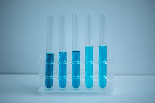 5 blue test tubes placed in a medical tube rack with a white background, Medical concept. photo