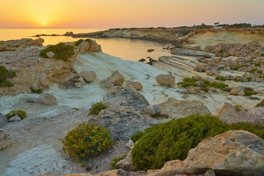 The stone coast of the Mediterranean Sea at sunset. photo