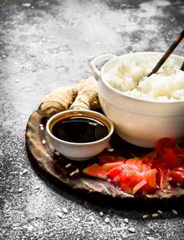Asian food. Boiled rice with soy sauce and pickled ginger. On an old rustic background. photo