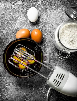 Baking background. Blend eggs with a mixer to make a dough. photo