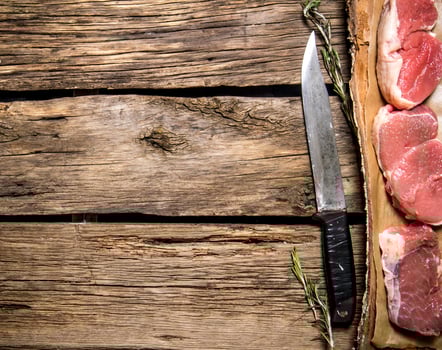 Pieces of raw meat with a butcher knife. photo