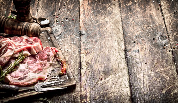 Raw meat background. Pieces of raw steak with spices and herbs. On wooden background. photo