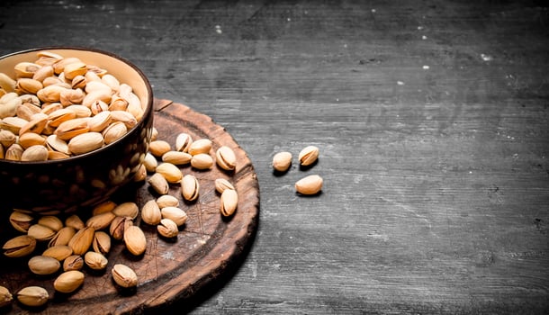 Pistachios in a bowl on the old Board. photo