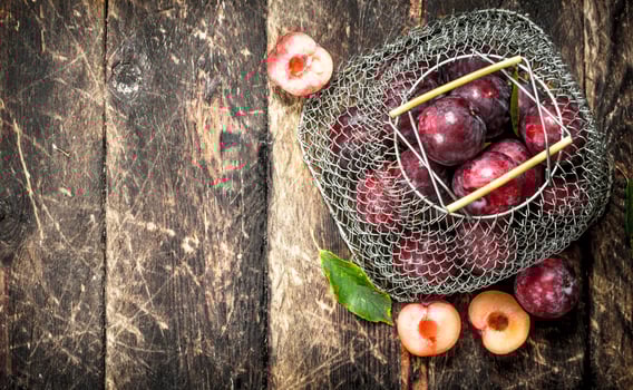 Fresh plums in a mesh bag. photo