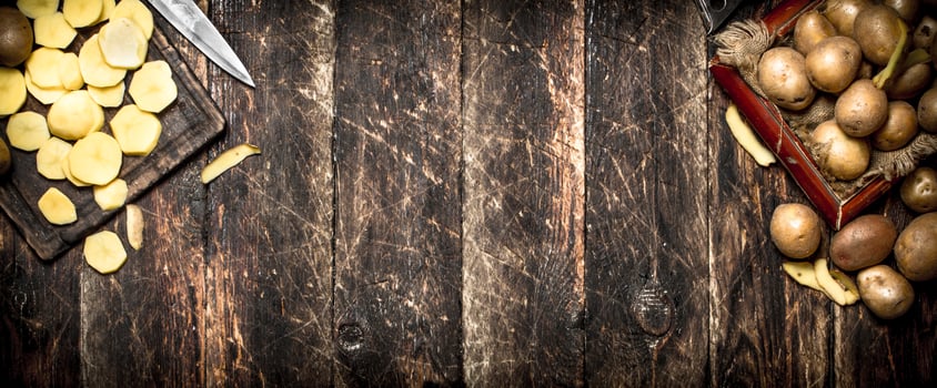 The sliced potatoes on an old wooden Board. On wooden background. photo