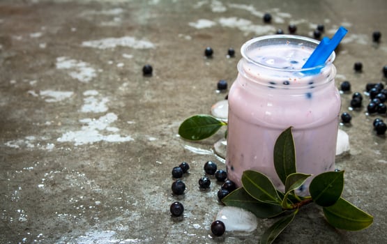 Blueberry smoothie with ice. On stone background. photo