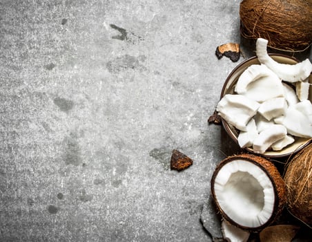 Coconut pulp in a bowl and whole coconuts. photo