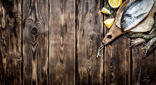 Sea fish with lemon slices on a cutting Board. photo