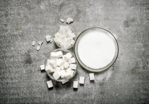 Different types of white sugar in a glass . photo