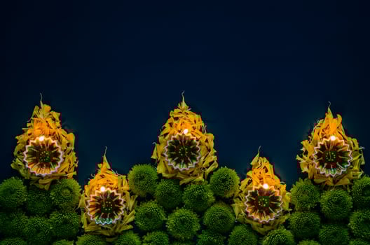 Clay diya lamps set as flame shape lit to celebrate for Diwali festival with colorful flowers on dark blue background. photo