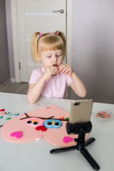 A blogger girl makes a felt craft for Valentine's Day in the shape of a heart. The concept of children's creativity and handmade. photo