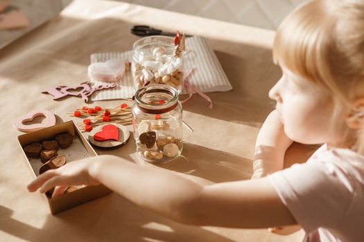 A little girl blogger makes a sweet Valentine's Day gift with her own hands. A gift for the holiday, a video blog entry. photo