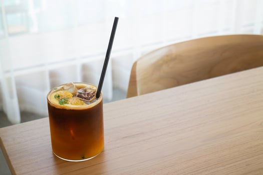 Iced black orange coffee on wooden table photo
