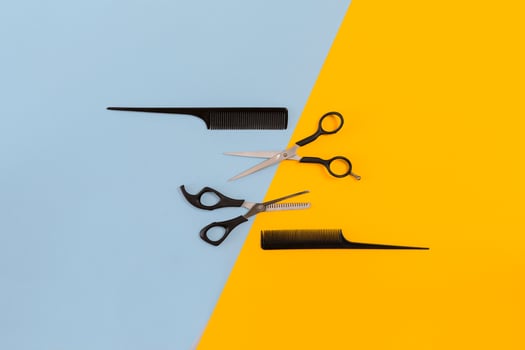 Hairdresser set with various accessories on orange and blue background photo