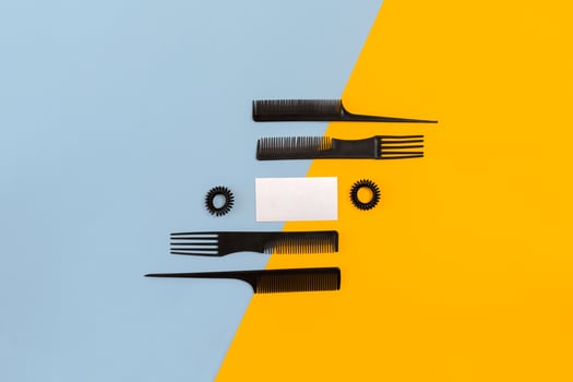 Hairdresser set with various accessories on orange and blue background photo