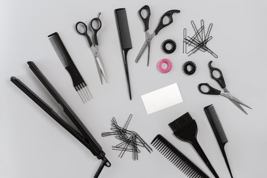 Hairdresser set with various accessories on gray background photo