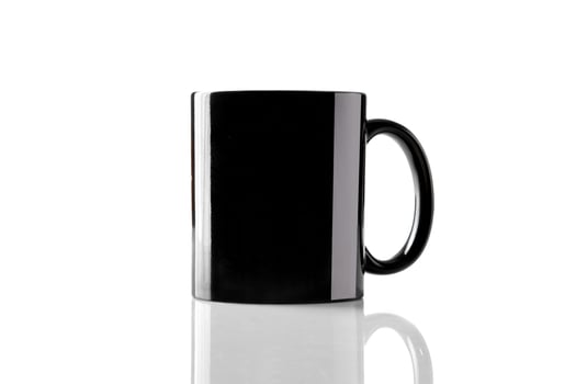 Black porcelain mug for coffee or tea on glossy surface isolated on white studio background. Mock up, template. Branding area. Close up, copy space photo