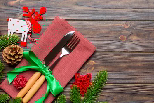 Top view of flatware tied up with ribbon on napkin on wooden background. Christmas decorations and reindeer with empty space for your design. New Year holiday concept photo