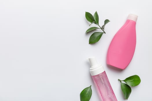Organic cosmetic products with green leaves on white background. Copy space, flat lay photo