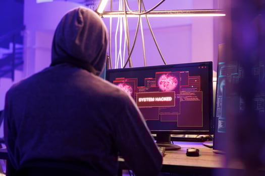 Hacker getting system hacked notification on computer screen after breaking into database server. Criminal in hood hacking website to steal confidential information at night photo