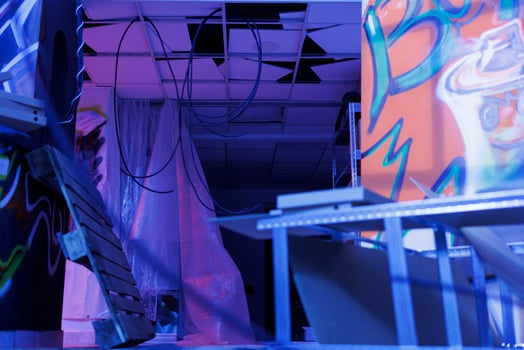 Destroyed old space with bright lights turned into ruin, deserted urban ghetto glowing in the darkness of disintegration. Neglected abandoned place with fluorescent purple light. photo