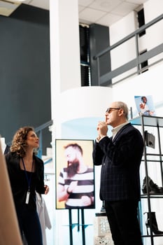 Showroom manager helping senior shopper choosing right sunglasses in modern boutique. Senior customer shopping for casual wear, buying fashionable clothes and stylish accessories in clothing store photo