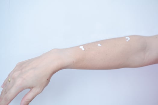 Woman's arm with skin cream waiting for skin care rub photo