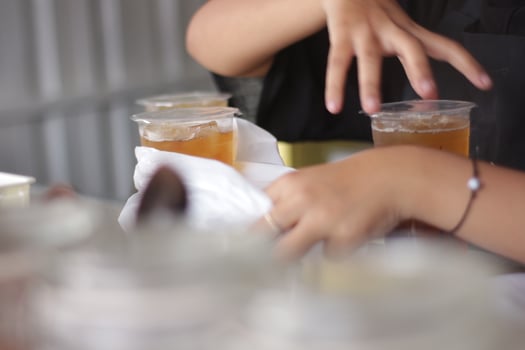 Hand of Indonesian street vendor prepares a glass of iced photo