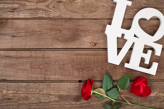 Red rose and box over wooden background photo