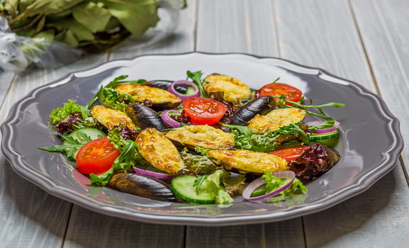 Fresh vegetable salad, healthy food, organic cucumbers, mussels, tomatoes and salad leaves photo