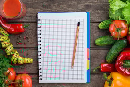 Glass of tomato juice with vegetables and measuring tape on table close-up photo