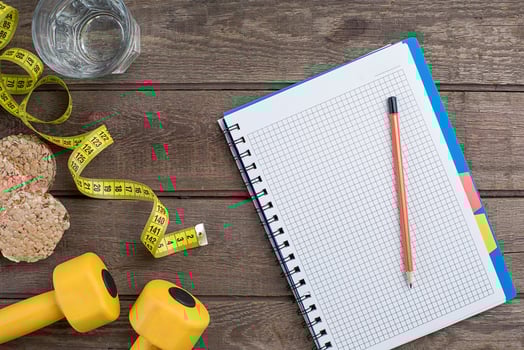Glass of water with vegetables and measuring tape on table close-up photo