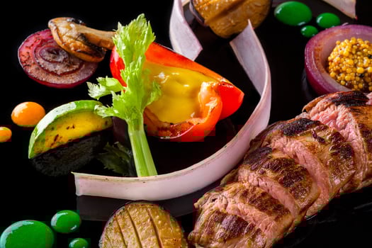 Sliced meat with fresh herbs, vegetables and spices on black background, top view photo