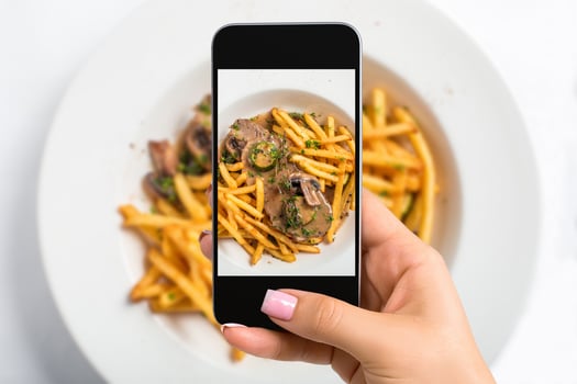 Shooting food on phone's camera. Meat with mushroom sauce and french fries photo
