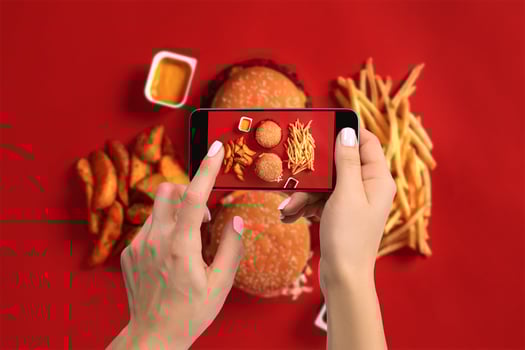 A young woman taking photo of food on smartphone, photographing meal with mobile camera