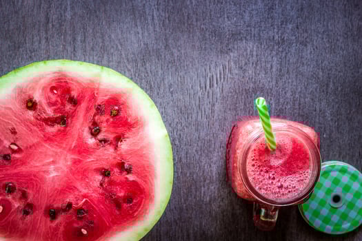 Watermelon smoothie and a half of fresh watermelon on dark wooden background. Flat lay or top view. photo