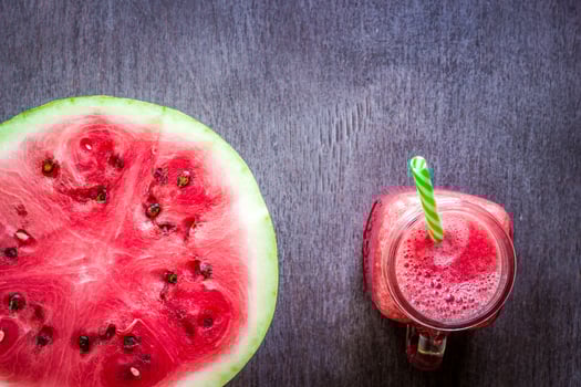 Watermelon smoothie and a half of fresh watermelon on dark wooden background. Flat lay or top view. photo
