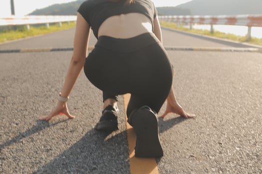 Young lady running on a rural road during sunset photo