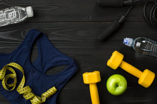 Athlete's set with female clothing and bottle of water on dark background photo