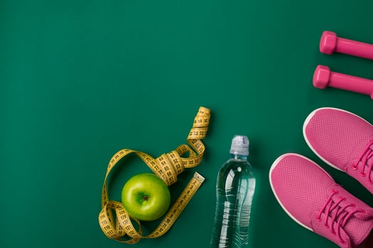 Workout plan with fitness food and equipment on green background, top view photo